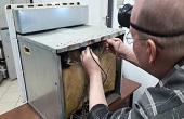 мастер проверяет напряжение на ТЭНе в духовом шкафе Bosch